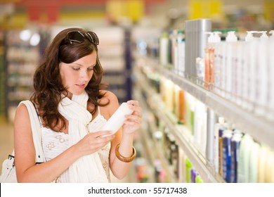 Shopping - Young Woman Holding Bottle Of Shampoo In Supermarket