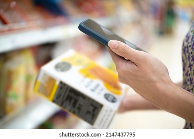 Shopping. Young Woman Scans The Composition Of The Body Cream. Modern Technology In Everyday Life. Close Up