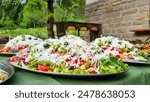 Shopska salad: close up of traditional Bulgarian salad with fresh raw vegetables and white cheese. Eating healthy dishes. Eating out, colourful seasonal food.