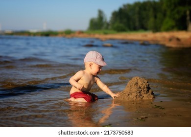 The Shore Of The Gulf Of Finland With A View Of The Sandy Spit And A Boy Sitting In The Water.