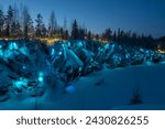 The shore of the Marble Canyon in aquamarine illumination on a January evening. Ruskeala Mountain Park. Karelia, Russia