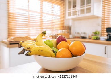 Short of Basket and fresh fruits on wooden table in kitchen at home. Mix variety of fresh juicy colorful healthy fruits in basket on dining counter in house. - Powered by Shutterstock