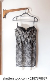 A Short Black Grey Bridesmaid Dress With Embroidery And Sequins Is On A Hanger On The Wall