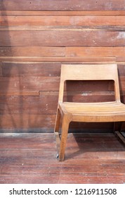 Short Leg Wooden Chair Near The Old Plank Wall For Relaxing Outside The Meeting Room.