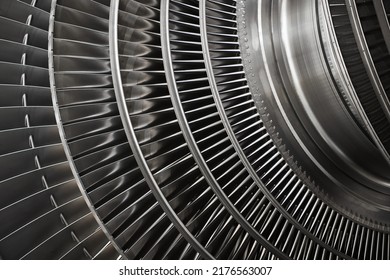 Short and long metal blades of high-speed steam turbine in workshop of industrial equipment production plant extreme closeup
