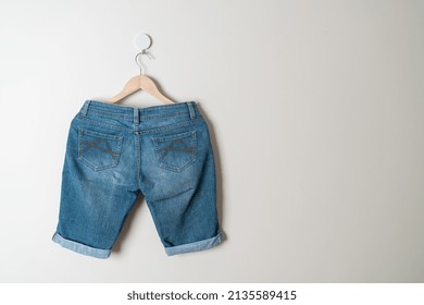 Short Pants Jeans Hanging With Wood Hanger On Wall