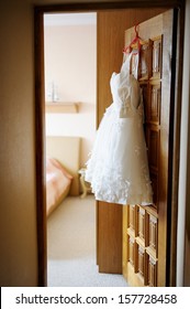 Short Wedding Dress Hanging On A Door