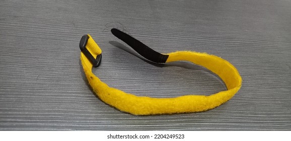 Short Yellow Strap On A Brown Table