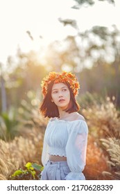 A Short-haired Woman Wears A Maple Leaf Crown In A Meadow.