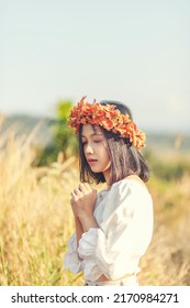 A Short-haired Woman Wears A Maple Leaf Crown In A Meadow.