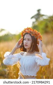 A Short-haired Woman Wears A Maple Leaf Crown In A Meadow.