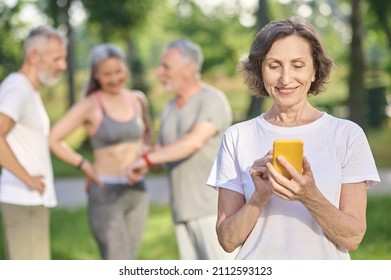 Short-haired Woman In A White Tshirt With A Smartphone