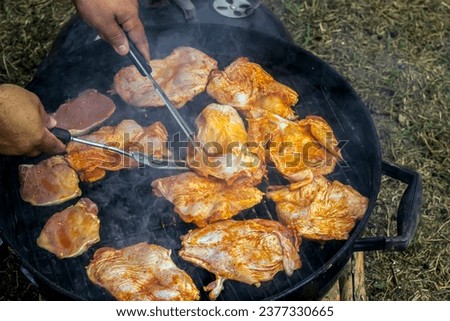 Shot from above of man preparing a delicious barbecue steaks in nature