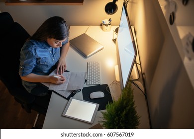 Shot From Above Of A Young Woman Working Late At Night.