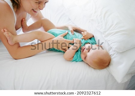 Shot of an adorable baby girl playing together with her mother on the bed at home