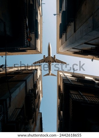 Shot of aeroplane flying above glass office buildings