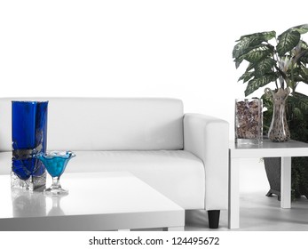 Shot Of A All White Living Room With A Green Plant And A Blue Glass Vase.