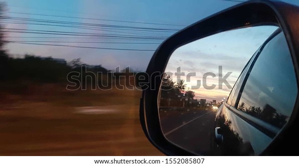 Shot from the angle of a car mirror that runs\
on the road at speed\
\
