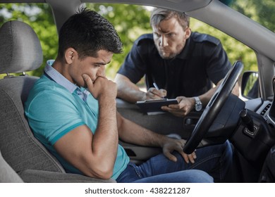 Shot Of An Angry Policeman Talking To A Sad Driver