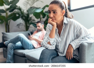 Shot Of Angry Young Couple Sitting On Couch Together And Looking To Opposite Sides At Home.