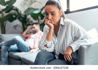 Shot Of Angry Young Couple Sitting On Couch Together And Looking To Opposite Sides At Home.