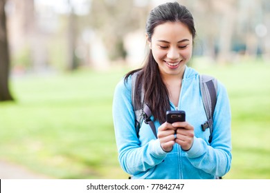 A Shot Of An Asian Student Texting On The Phone