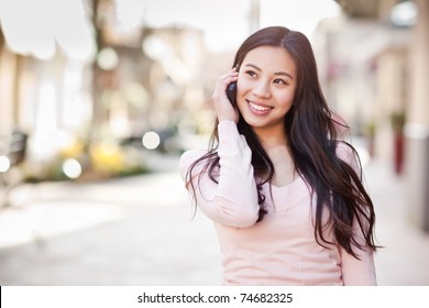 A Shot Of An Asian Woman Talking On The Phone