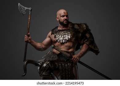 Shot Of Assaulting Viking With Muscular Build And Fur Holding Two Axes.