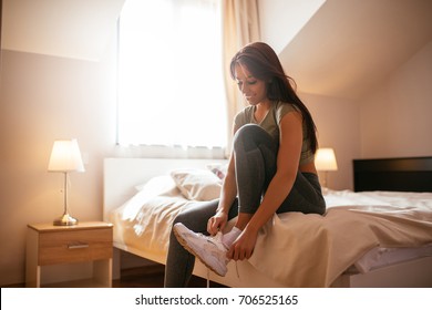 Shot of an athlete young woman getting ready for a run in the apartment. - Powered by Shutterstock