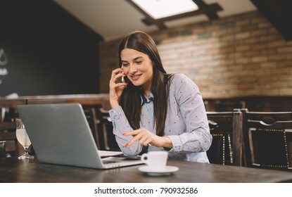 Aufnahme einer attraktiven Geschäftsfrau, die auf ihrem Arbeitsplatzrechner mit Laptop arbeitet.