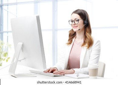 Shot of an attractive customer support agent sitting at her workplace and chatting online. - Powered by Shutterstock