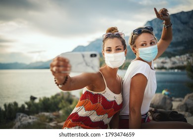 Shot Of Attractive Female Friends Wearing With Protective Mask And Making Selfie With Smartphone While Exploring The Wonderful City Of Mediterranean.