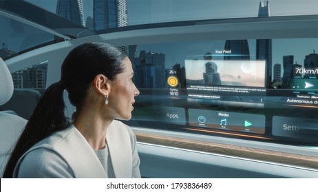 Shot of Attractive Female Reading the News on a Futuristic Augmented Reality Interface while Riding in an Autonomous Self-Driving Car. Modern City with Glass Skyscrapers in a Car Window.