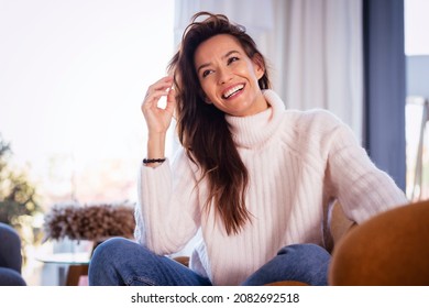 Shot of attractive woman wearing casual clothes while relaxing in the armchair at home. - Shutterstock ID 2082692518