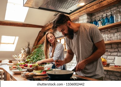 Shot of an attractive young couple cooking in the kitchen