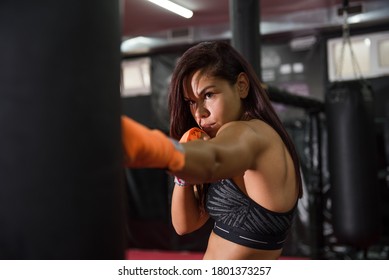 Shot Of An Attractive Young Female Kick Boxer Working Out In The Gym. She Punching Boxing Bag.