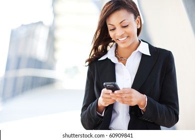 A shot of a beautiful black businesswoman texting - Powered by Shutterstock