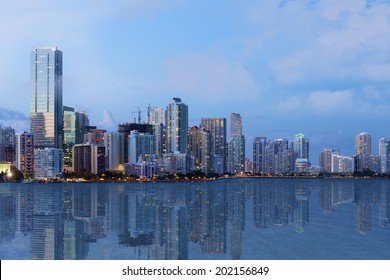 A shot of beautiful Downtown Miami skyline after sunset with reflection in the water. All logos and advertising removed.