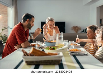 Shot of beautiful kind family talking while eating together in the kitchen at home - Powered by Shutterstock