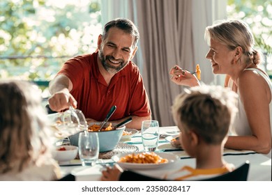 Shot of beautiful kind family talking while eating together in the kitchen at home - Powered by Shutterstock