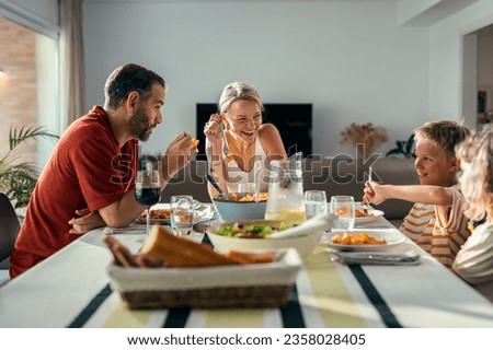 Shot of beautiful kind family talking while eating together in the kitchen at home