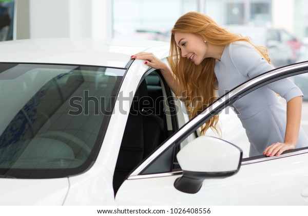 Shot of a beautiful long haired young woman\
getting in a new car while shopping for an auto at the dealership\
showroom copyspace comfort luxury lifestyle driving ownership\
choosing leasing rental.