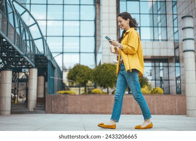 Shot of a beautiful mature businesswoman texting. Mature businesswoman walking outdoors and using cellphone. Female business professional walking outside and texting from her mobile phone. - Powered by Shutterstock