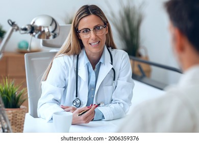 Shot Of Beautiful Mature Female Doctor Talking While Explaining Medical Treatment While Prescribing Medication To Patient In The Consultation.