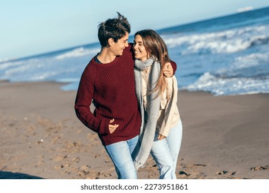 Shot of beautiful young couple in love enjoying the day in a cold winter on the beach. - Powered by Shutterstock