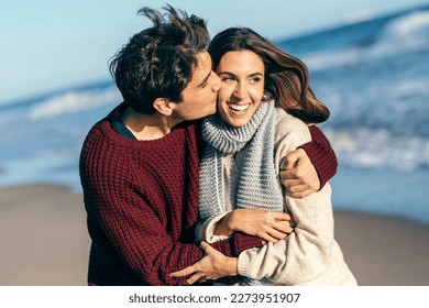 Shot of beautiful young couple in love enjoying the day in a cold winter on the beach. - Shutterstock ID 2273951907