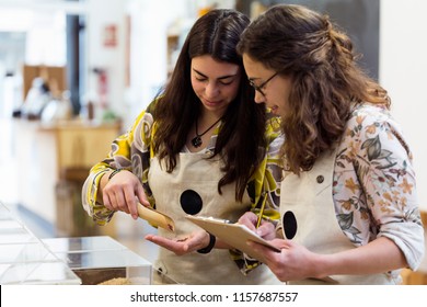 Shot of beautiful young saleswomen doing inventory in organic store. - Powered by Shutterstock