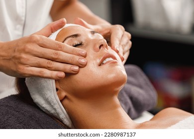 Shot of a beautiful young woman enjoying face massage at the beauty salon. - Shutterstock ID 2280987137