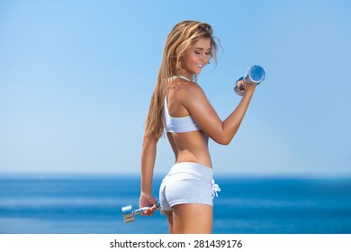 Shot Of A Beautiful Young Woman Lifting Weights Outside