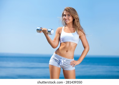 Shot Of A Beautiful Young Woman Lifting Weights Outside